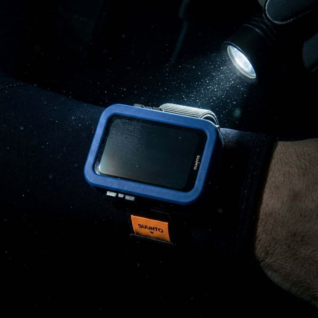 Schutzhülle für Suunto Nautic auf einem Handgelenk während des Tauchens mit einer Taschenlampe.