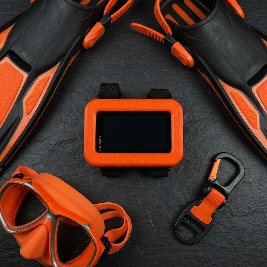 Hülle für Garmin Descent X50i, stylische orange Schutzhülle umgeben von Tauchzubehör.
